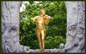 Golden statue of strauss in a park in Vienna