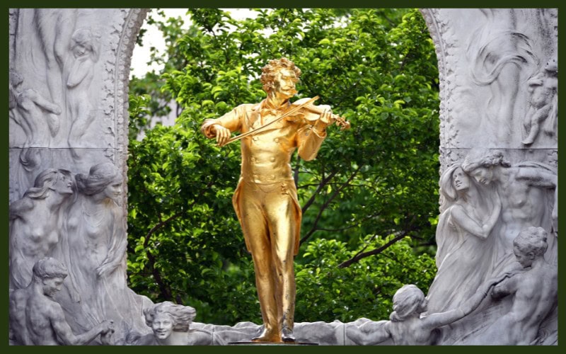 Golden statue of strauss in a park in Vienna