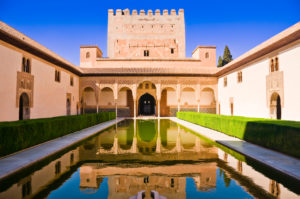Reflecting Pool in Alhambra Courtyard: Symmetrical courtyard with a reflecting pool in the Alhambra, Granada, showcasing the beauty of Moorish architecture, perfect for an Andalusia itinerary.