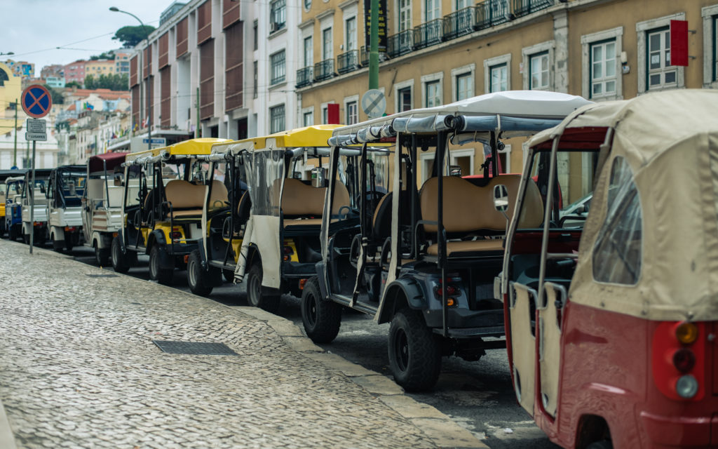 A line of tuk tuks on a street in Lisbon, Portugal