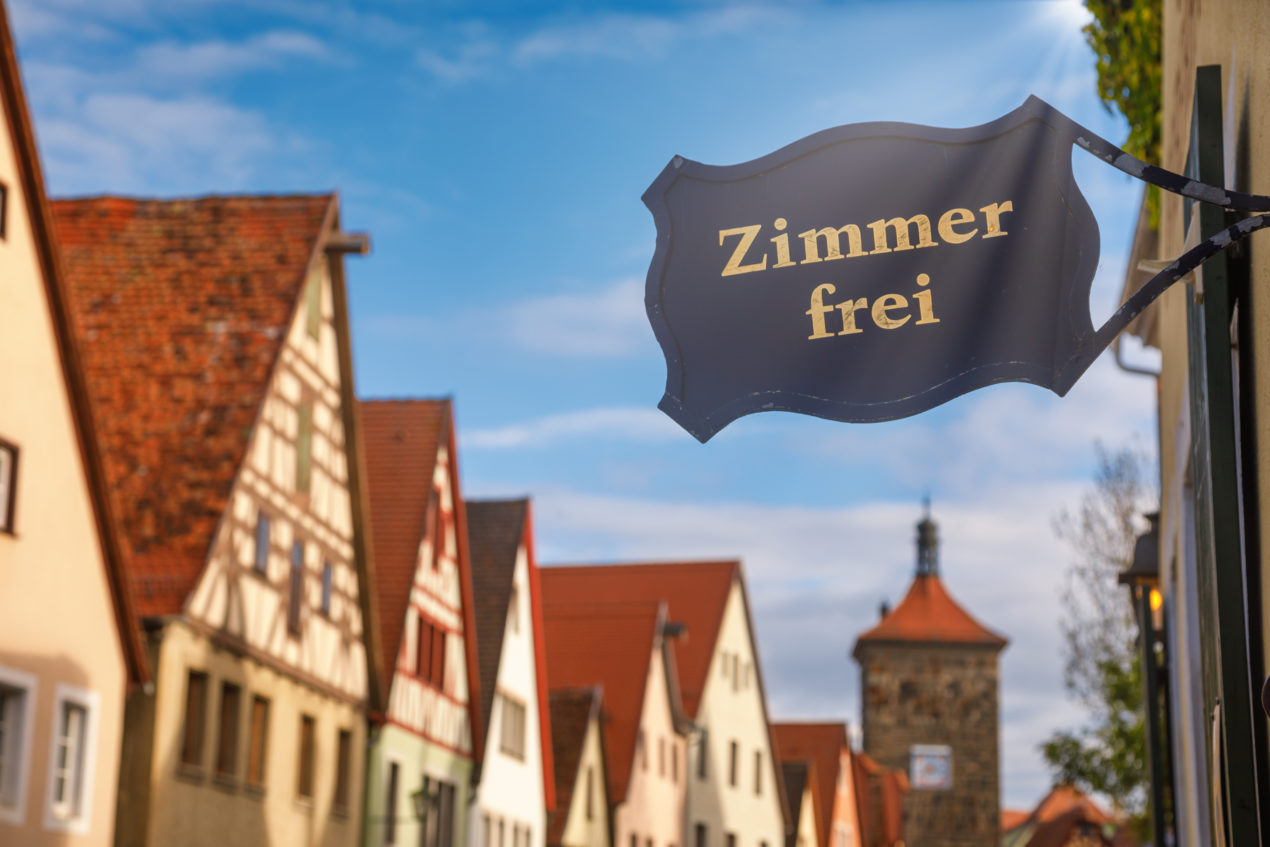 Row os half-timbered houses in Germany. A sign in the corner says "Zimmer Frei" which means "Rooms Free". The picture represents the theme of the post which is accommodation options in Germany.