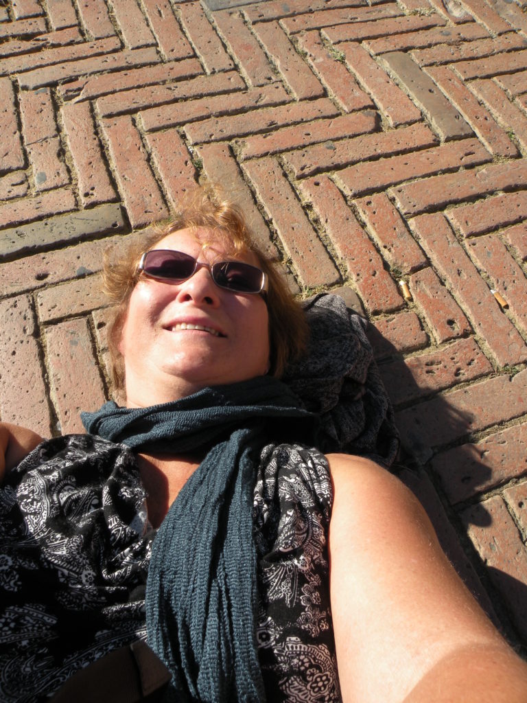 Carol lying on the 14th century bricks of the Campo in Siena