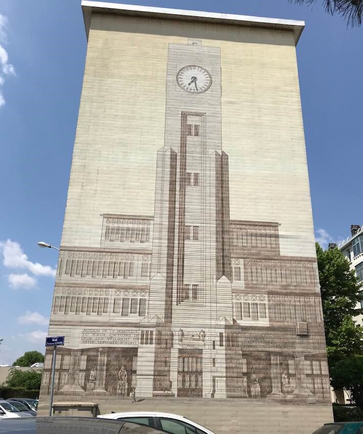 Large mural of a buidling with a clock tower on the side of a building in Lyon