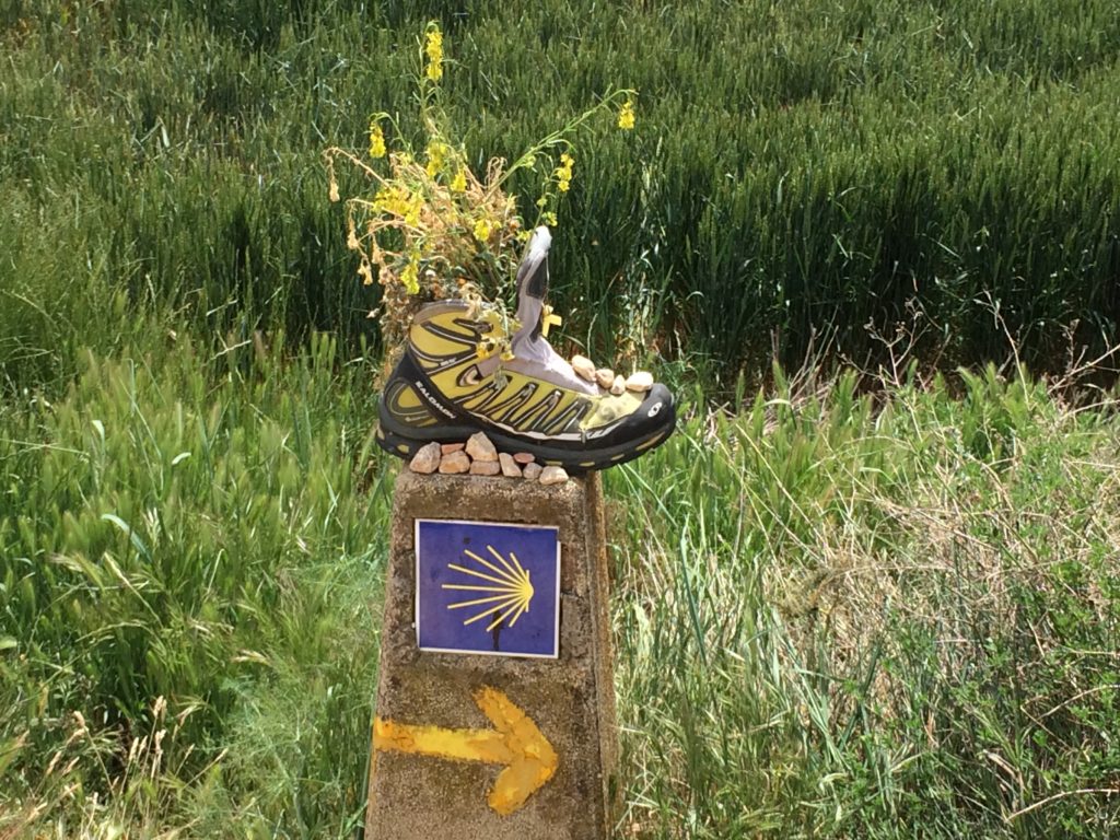 Marker along the Camino of Santiago with a running shoe