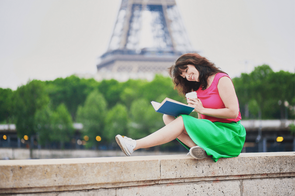 Woman reading a book with the Eiffel Tower in the background