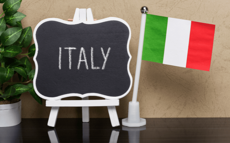 Italian flag next to a small blackboard with the word "italy" on it