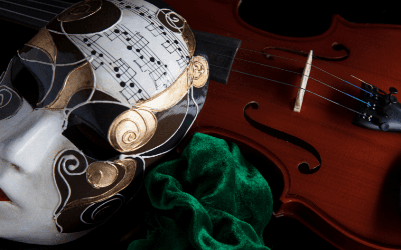 A mask and violin representing music in Venice, a place with many venues for concerts and performances