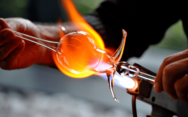 Close up of a glass ornament being heated with an orange flame