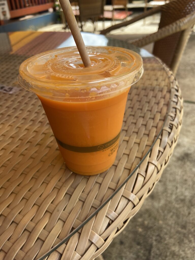 A cup full of the Kaupea Sundown juice--carrot, organge, tumeric, and aloe.