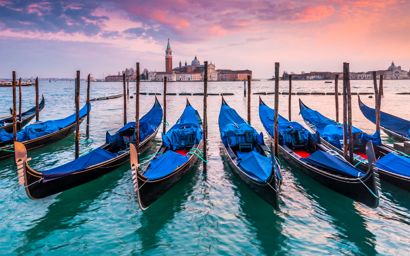 Gondolas bobbing on the Grand Canal in Venice at sunset