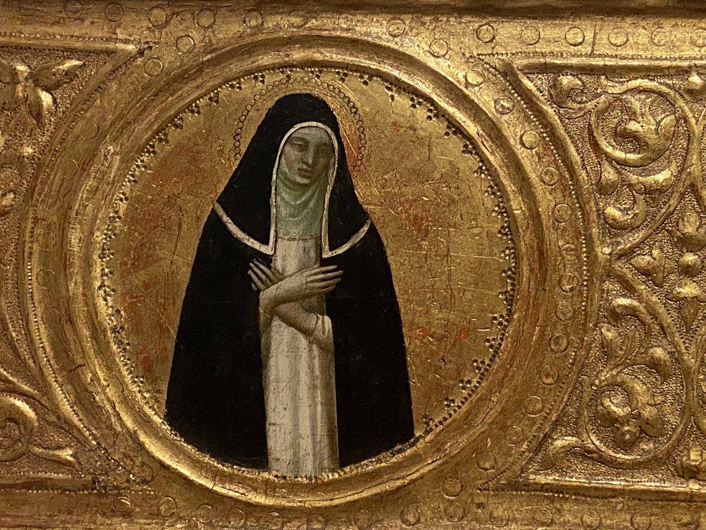 Medieval gold panel that includes a portrait of a female saint dressed in the black habit of a nun created by Fra Angelico included in the Medieval collection at the Courtauld Gallery in London.