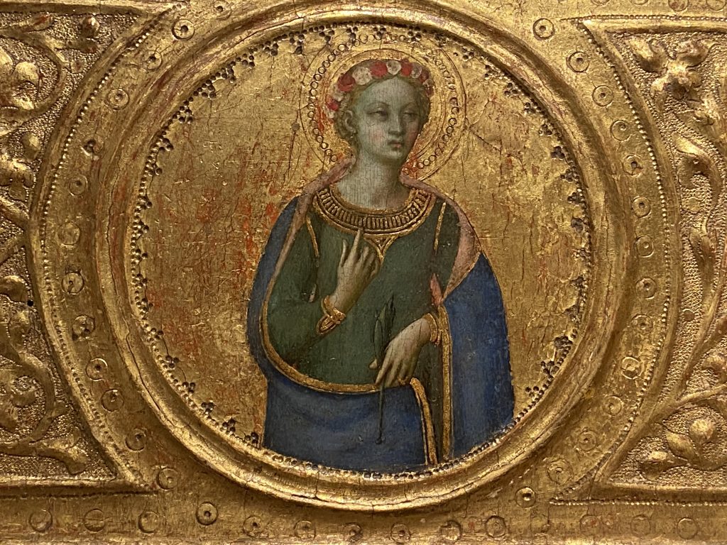 Medieval gold panel that includes a portrait of a female saint dressed in a blue robe trimmed with gold and created by Fra Angelico included in the Medieval collection at the Courtauld Gallery in London.