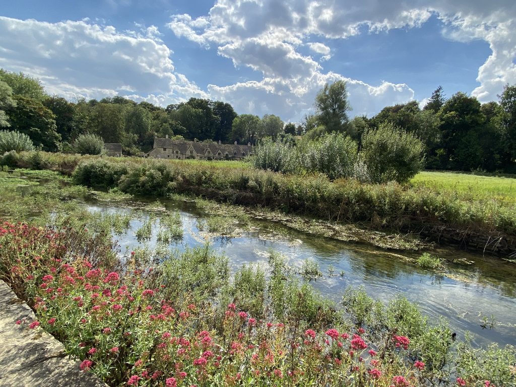 Vista of stream and Arlington Row cottages in Bilbury in the Cotswolds