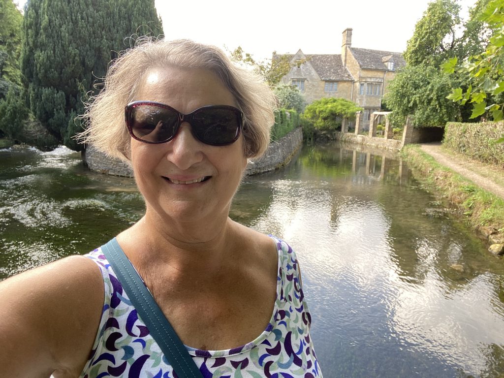 Carol Cram in front of a beautiful home in Bourton-on-the-Water in the Cotswolds