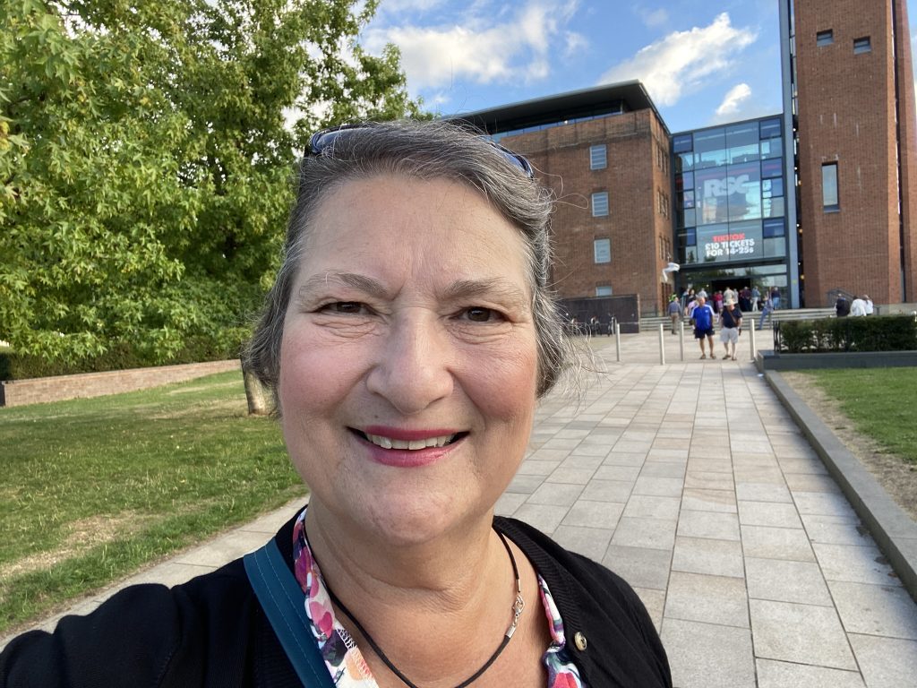Carol Cram in front of the RSC theatre in Stratford-upon-Avon