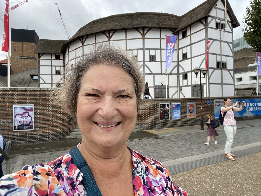 Carol cram in front of Shakespeare's Globe Theatre in London