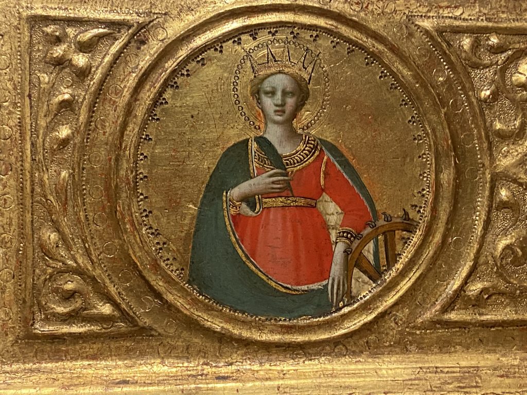 Medieval gold panel that includes a portrait of a female saint wearing a red gown trimmed with gold and a green cape, and created by Fra Angelico included in the Medieval collection at the Courtauld Gallery in London.