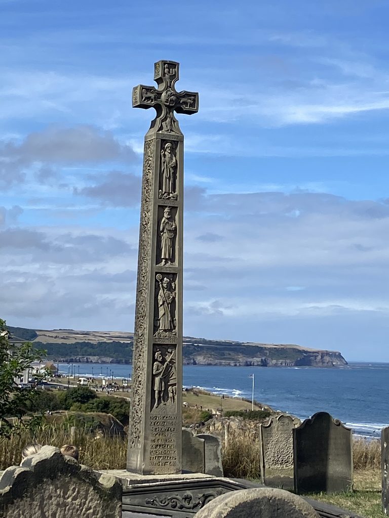 View of a large stone cross and the North Sea beyond from Whitby in Yorkshire
