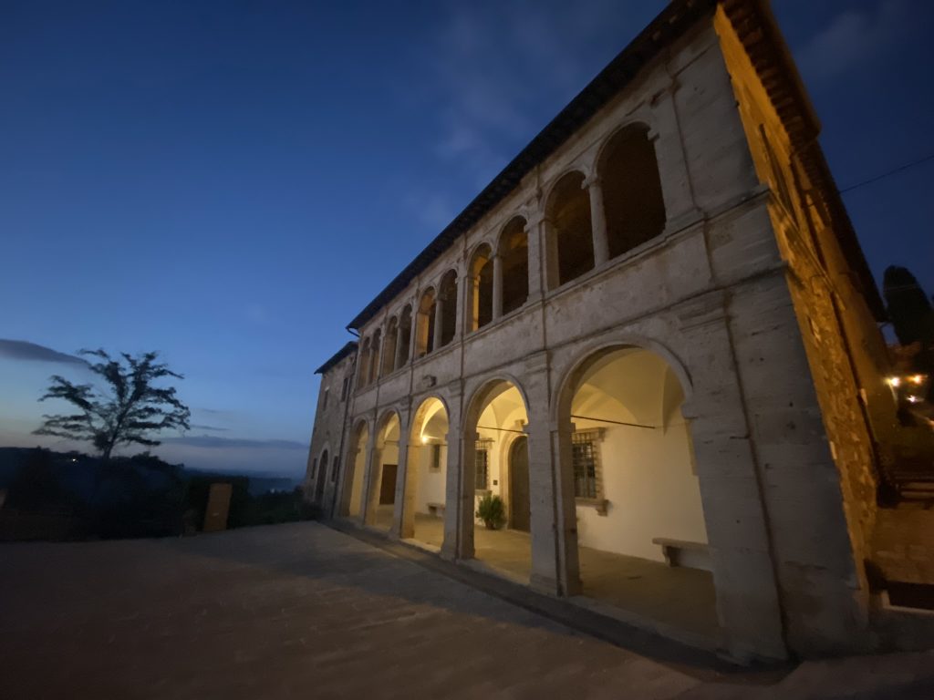 Large medieval buidling with porticos against a darkening sky in Montepulciano, Tuscany