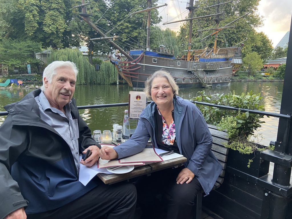 Carol and Gregg sitting at an outdoor table in Tivoli Gardens in Copenhagen