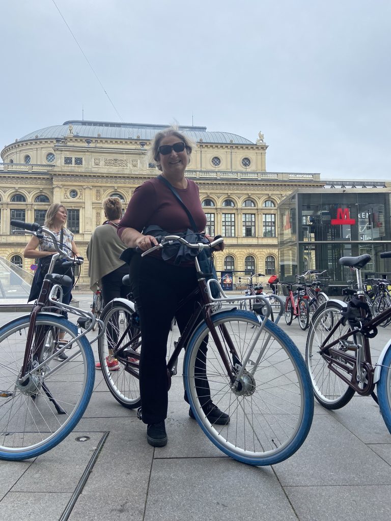 Carol Cram standing with a bike in Copenhagen prior to going on a bike tour