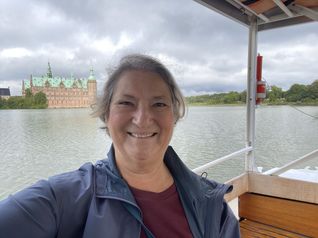 Carol Cram on the little launch crossing the lake to Fredericksborg in Denmark with the Fredericksborg  Castle in the background