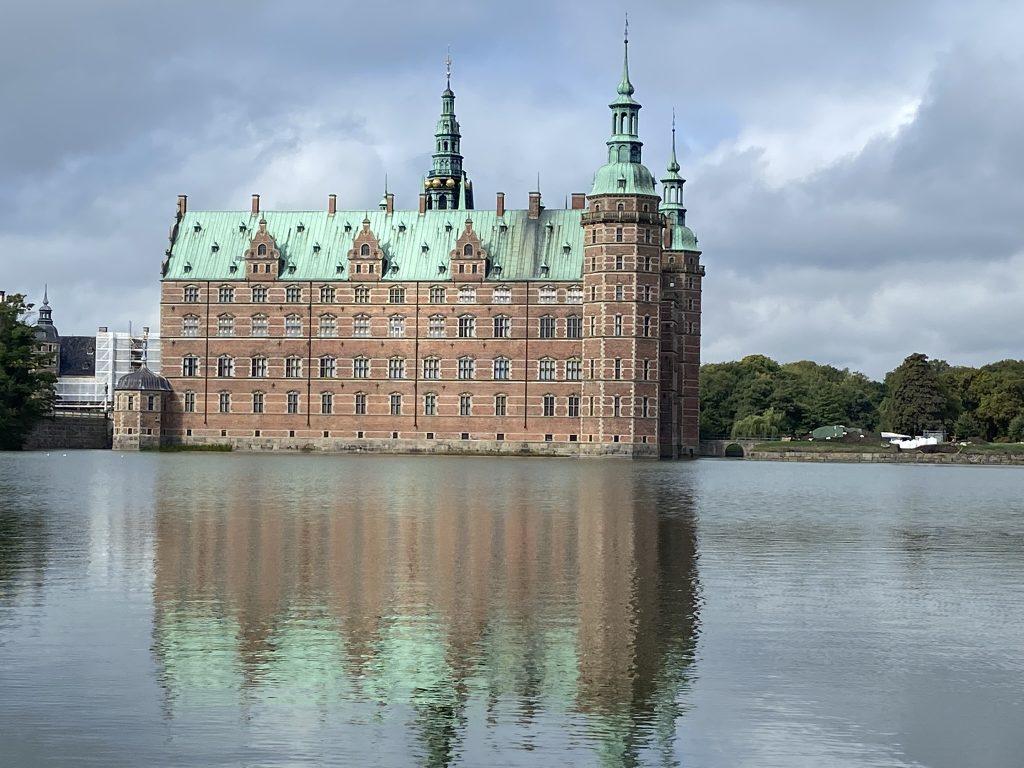 Fredericksberg Castle on a sunny day and reflected in the lake - perfect for a day trip from Copenhagen