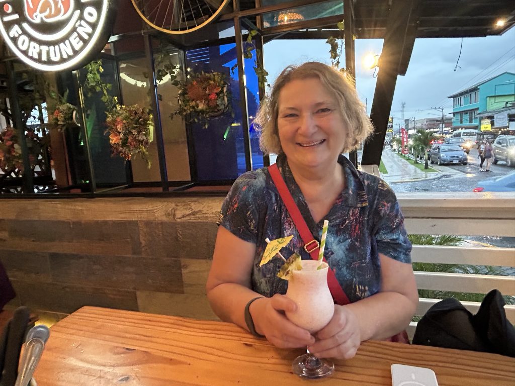 Carol Cram in a restaurant with a cocktail in La Fortuna in Costa Rica