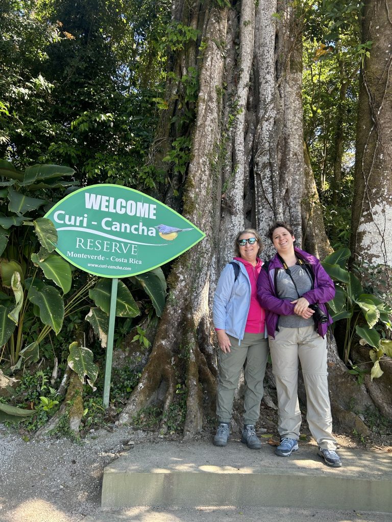 Carol Cram and Julia Simpson in front of a large fiscus tree in the Monteverde Cloud Forest in Costa Rica