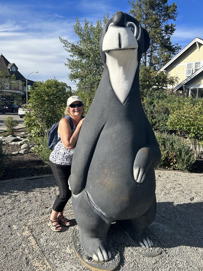 Carol Cram with Jasper Bear statue in Jasper, Alberta