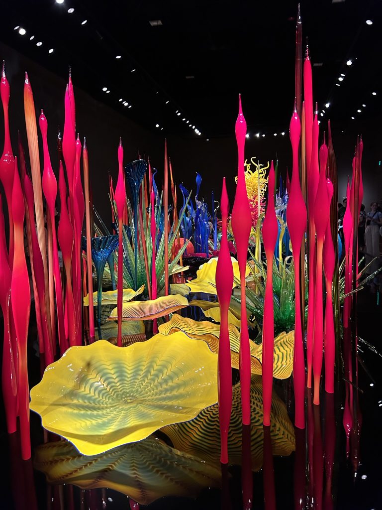 Chihuly bright and colorful sculptures with tall red fronds, flat shells, and large orbs