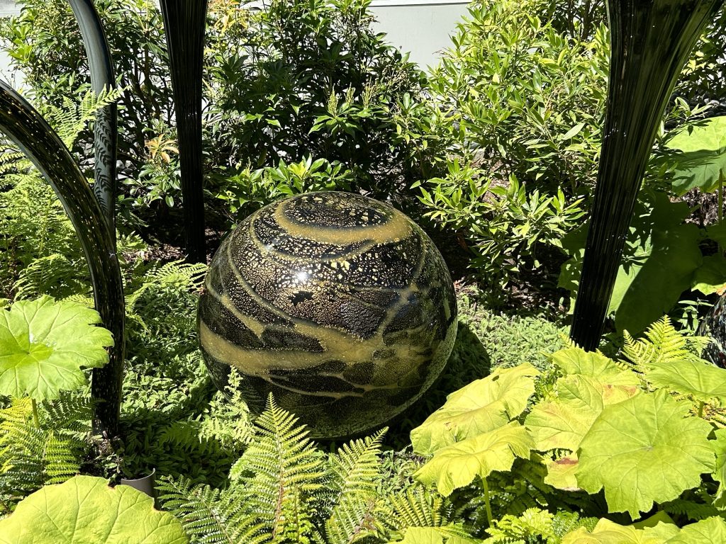 Large gold and black glass orb in the garden at Chihuly Garden and Glass in Seattle