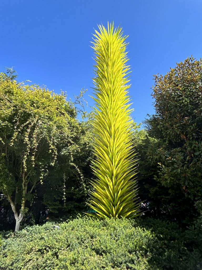 Large lime green vertical sculpture in the garden at Chihuly Garden and Glass in Seattle