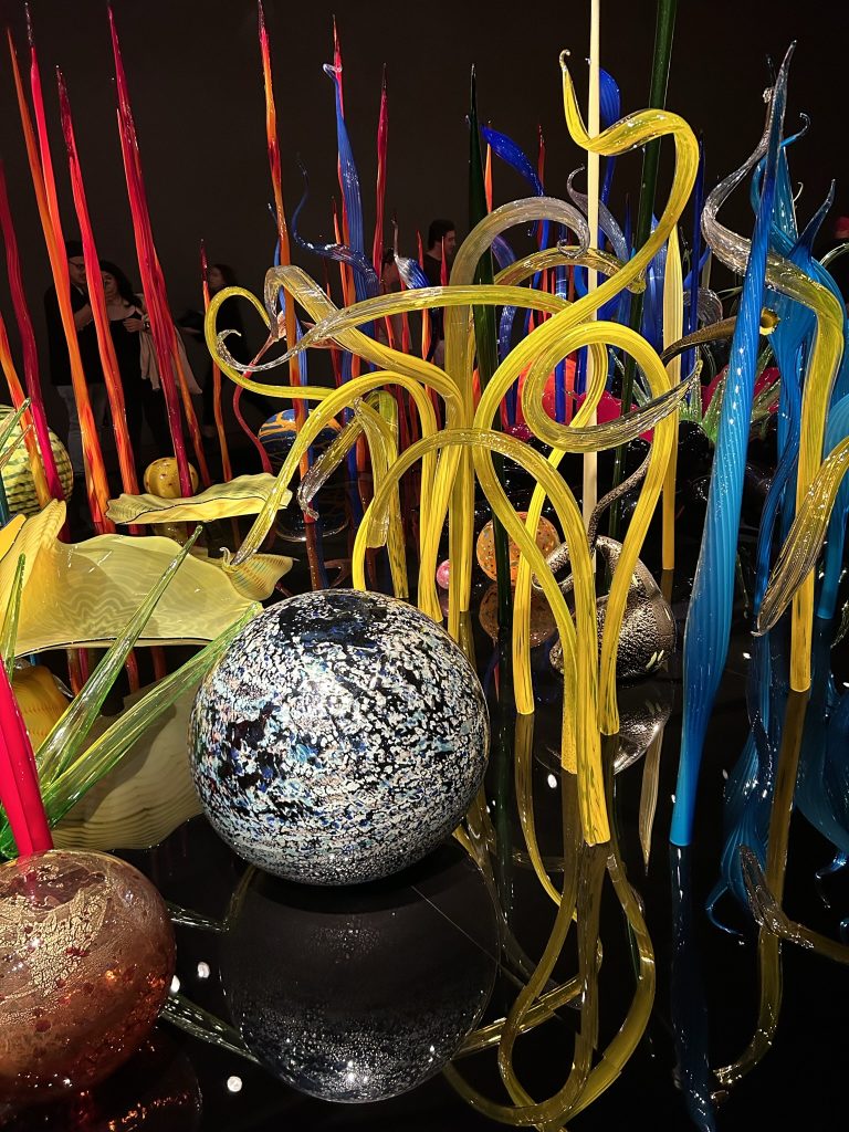 Chihuly bright and colorful sculptures with tall yellow fronds, flat shells, and large orbs