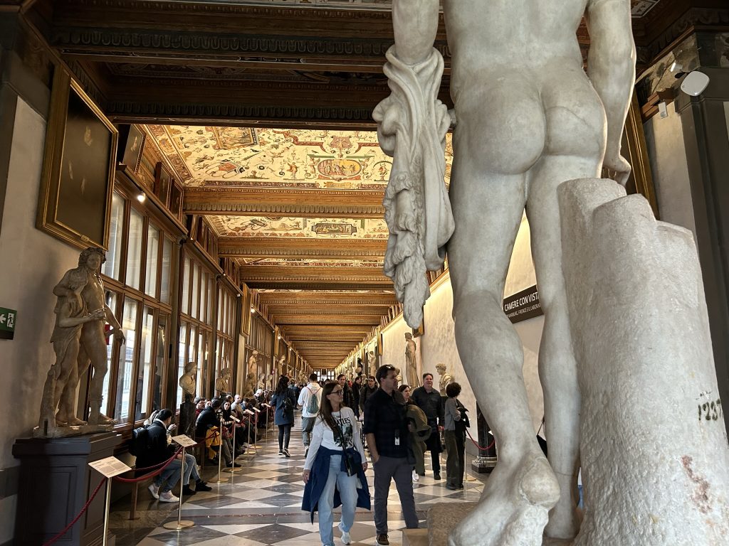 Crowds of people in a hallway in the Uffizi Gallery in Florence.