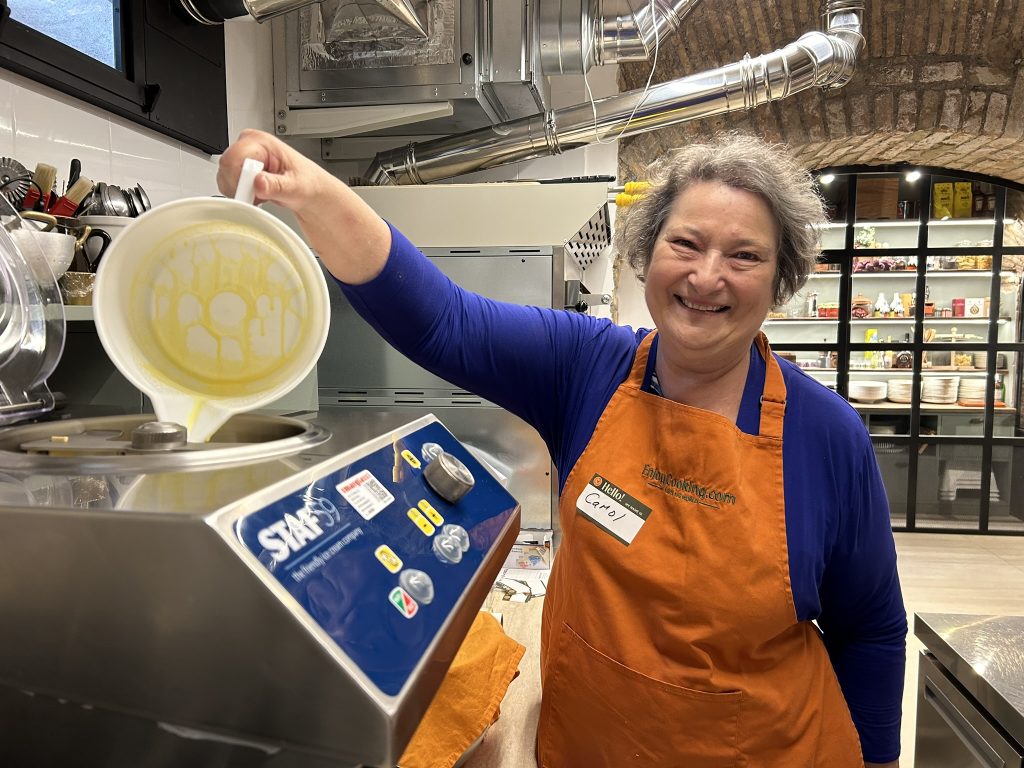 A pot of fresh milk being heated on an electric hot plate, the first step in preparing limone gelato during a Roman cooking class