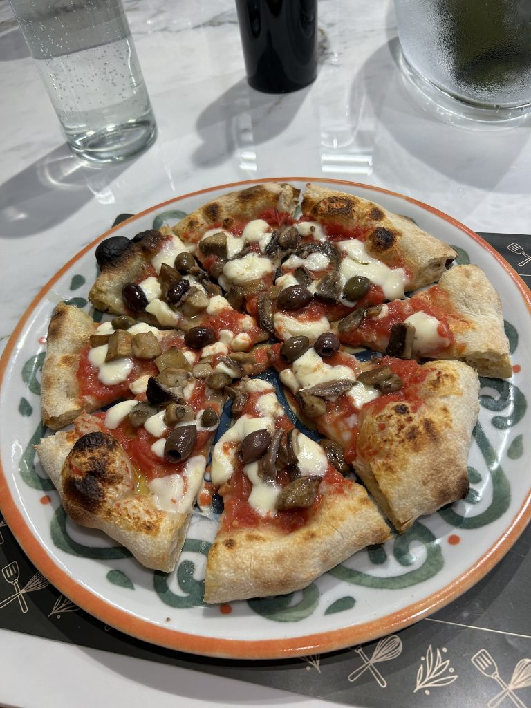 Finished pizza with anchovies and olives at cooking class in rome