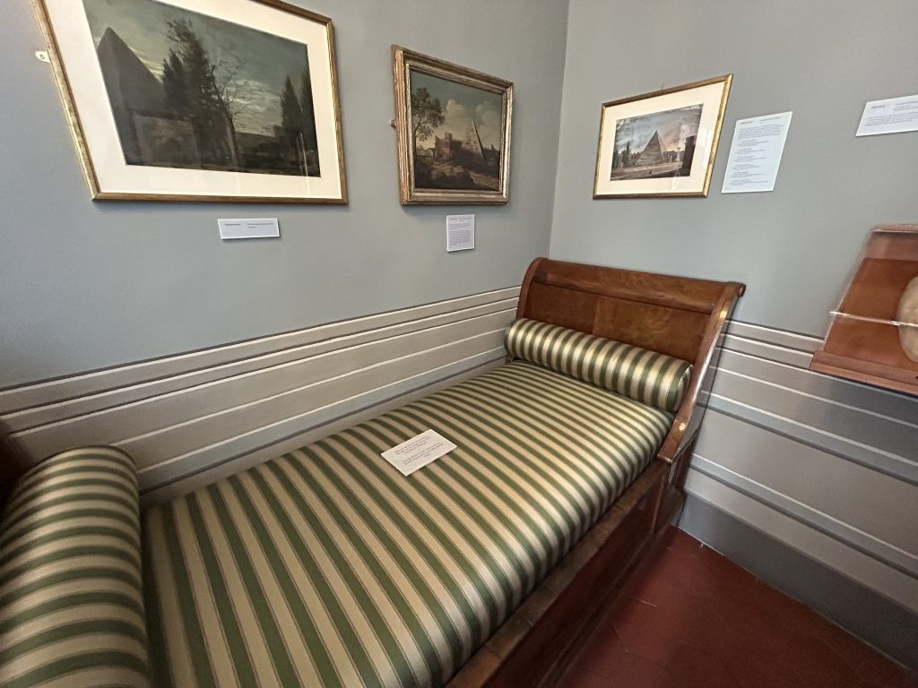 A simple bedroom where poet John Keats passed away, showcasing a modest bed and period furnishings.