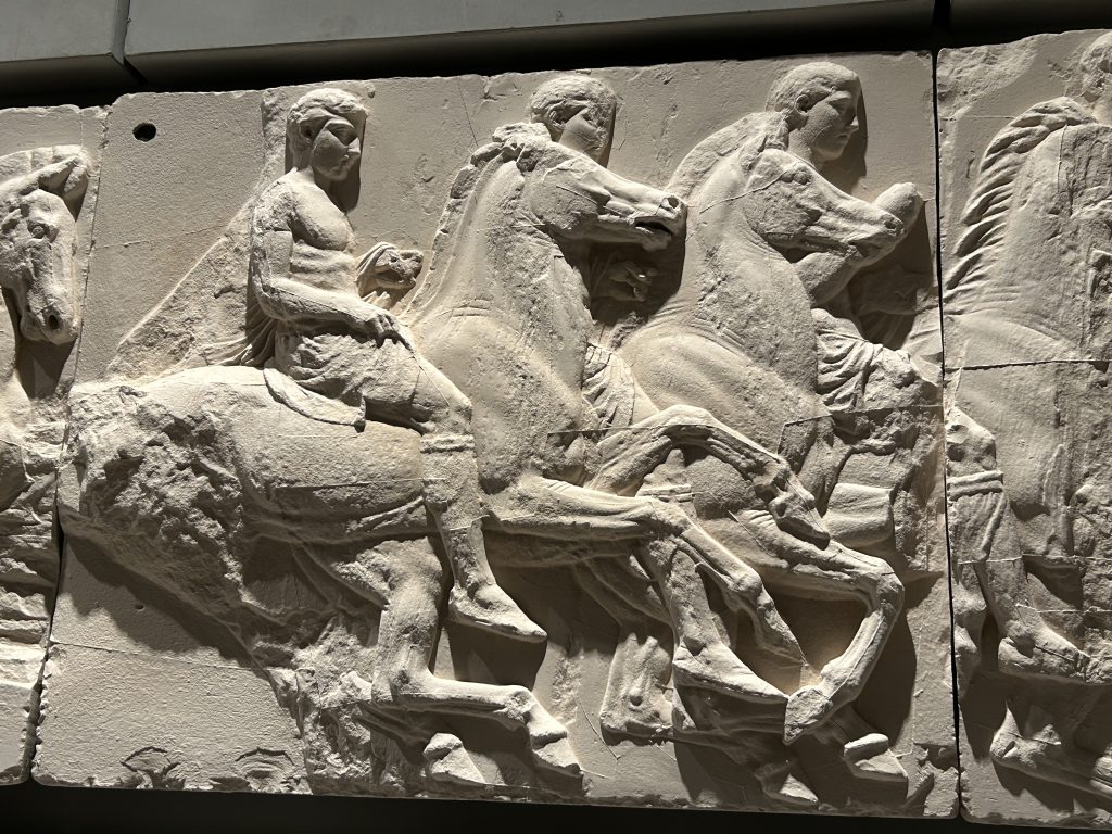 Portion of the frieze that once adorned the Parthenon at the Acropolis exhibited in the Acropolis Museum in Athens. This portion shows a carving of four men on horseback and is remarkably full of movement.