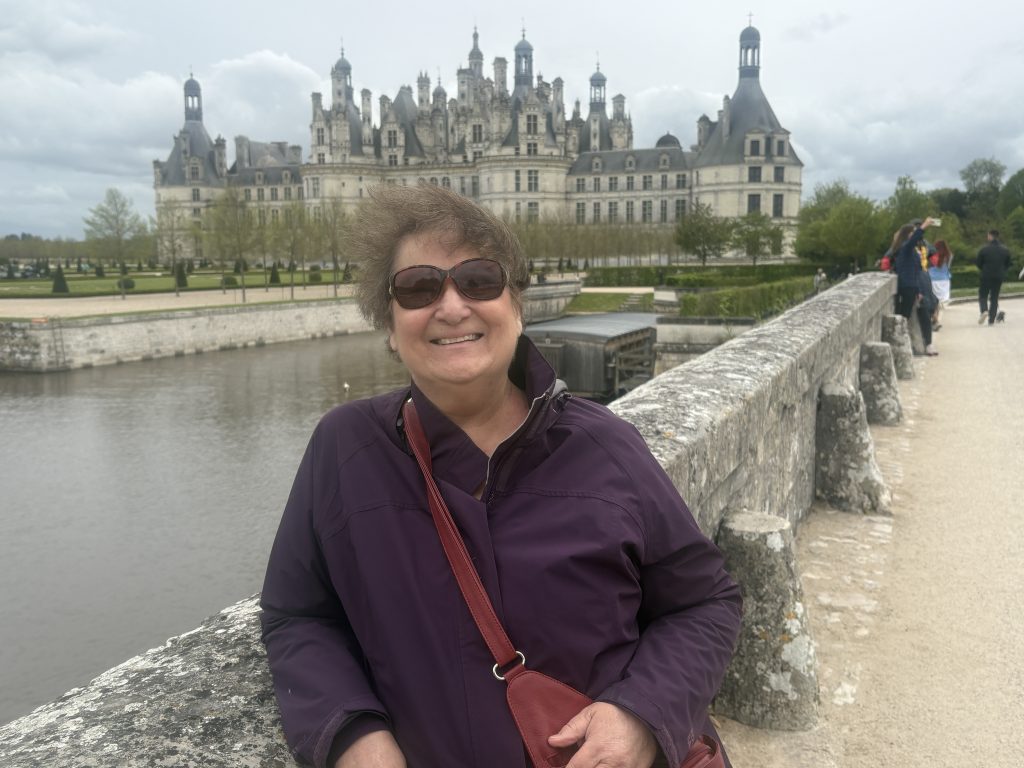 Carol Cram on the bridge leading to the chateau of Chambord with its multitude of turrets.