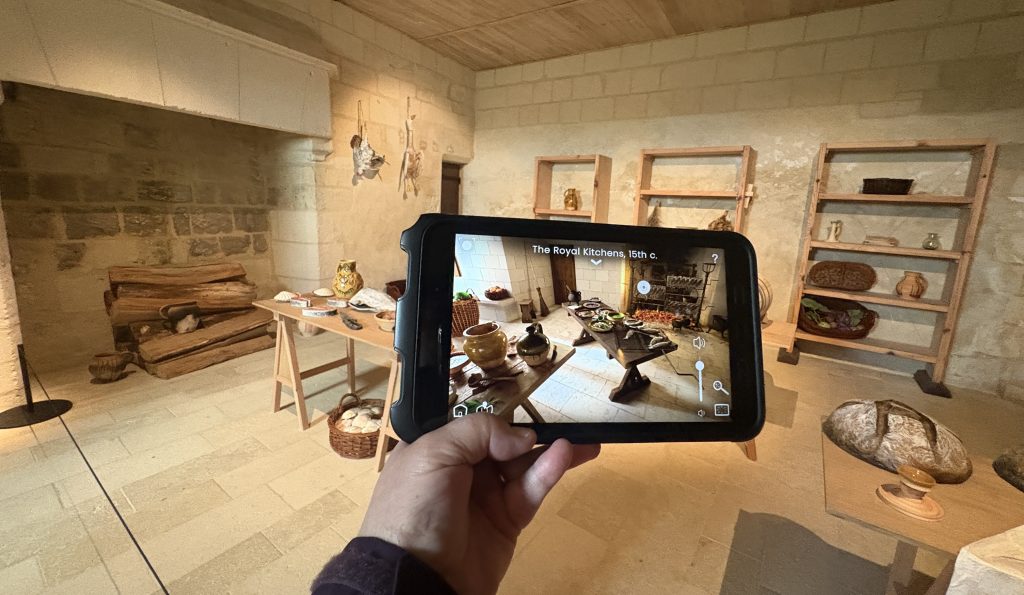 Medieval kitchen at Chinon castle with a histopad showing the kitchen on a screen in the foreground.