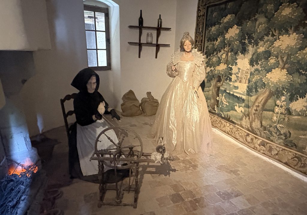 Diorama at Château d’Ussé features an elderly woman spinning thread while a princess stands nearby, recreating the Sleeping Beauty tale in this magical Loire Valley château.


