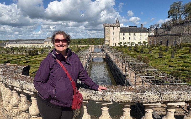 Carol Cram in front of the formal gardens at Villandry in the Loire Valley with the chateaux in the background.