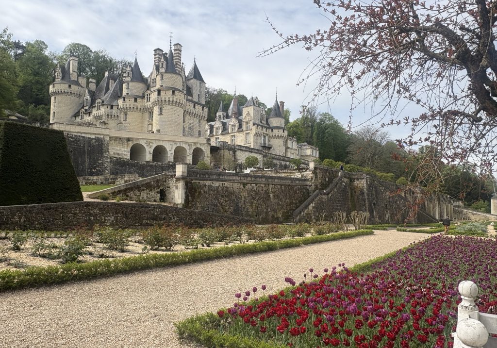 Fairytale architecture of Château d’Ussé with turrets and spires rising above manicured gardens, embodying the romantic allure of Loire Valley chateaux.

