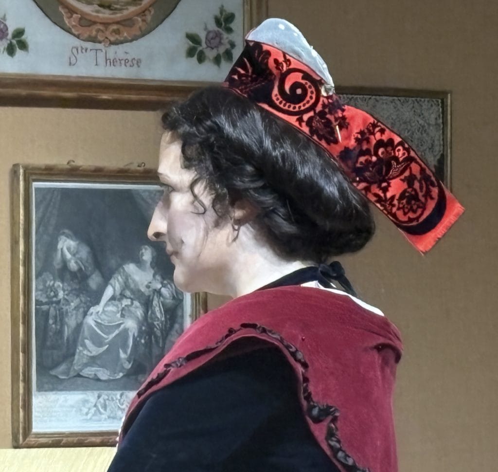 Manniquin showing a close up of the Arlesienne headress with velvet embossed ribbon on display at the Museom Arletan in Arles 