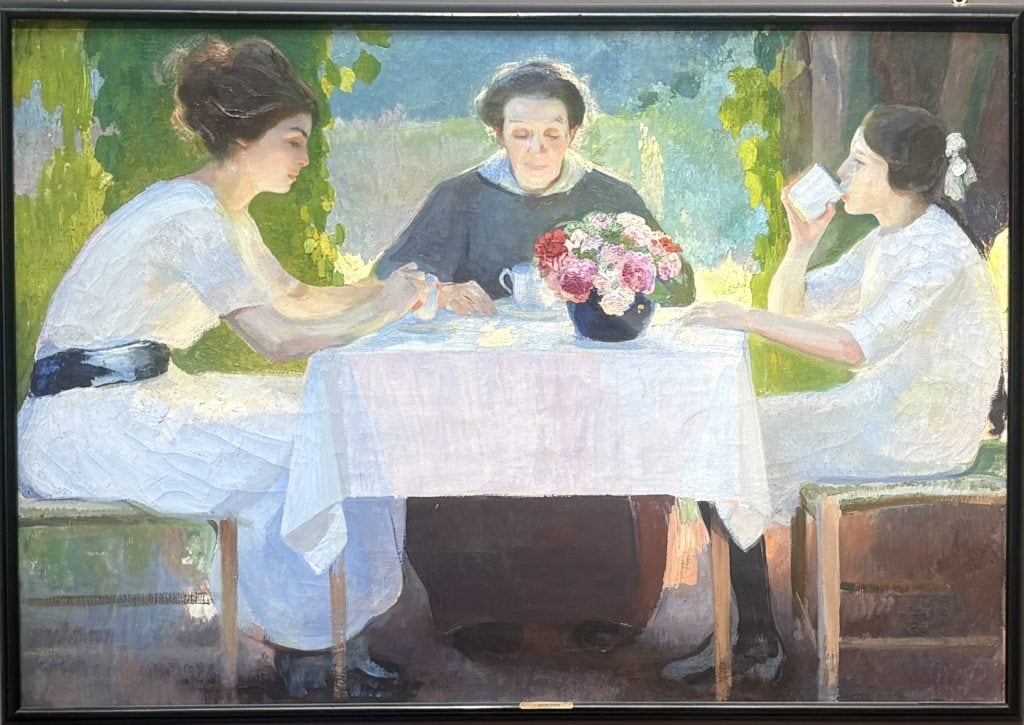 Painting called La Colazione Del Mattino of three people having breakfast painted in an early 20th century impressionist style by Amaedeo Bocchi in the Galleria d’arte moderna Ricci Oddi in Piacenza