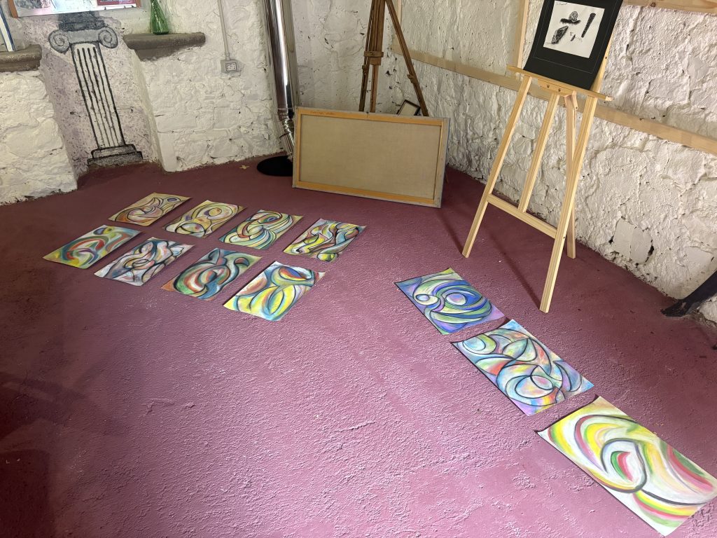 A selection of drawings by Gregg Simpson laid out on the floor of the art barn at the Casale di Clio, an art and writing retreat in Tuscany