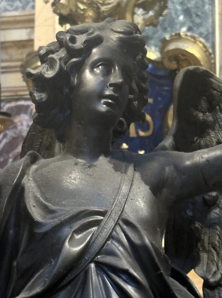 Close up of a black marble statue of an angel at Sant'Ignazio Baroque trompe d'oiell ceiling at Sant'Ignazio  taken  on a Rome Photography Tour with Rome Photo Fun Tours.
