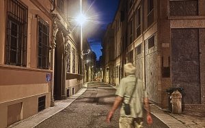 Deserted street in Piacenza at night with the figure of a man walking in the foreground