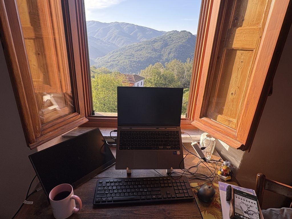 View of a laptop  computer with the view beyond of the Tuscany countrysidea Casale di Clio writing retreat 
